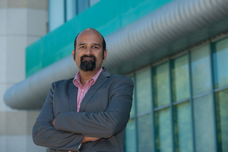 Headshot of Sunil Ghandi in front of McGaugh Hall at UC Irvine