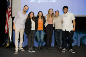 A group of people stand in front of a presentation board