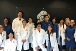 A group of people stand in front of the CNLM sign