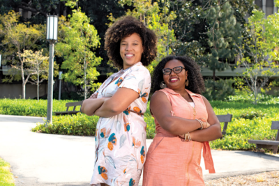 UC Irvine Neuroscience Doctoral Students, Elena Dominguez and Angeline Dukes, pose back-to-back at UCI ring road