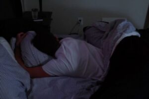 A male in sleeping in bed.