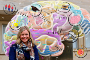 A young woman, Markie Pasternak, smiles in front of a brain illustration.