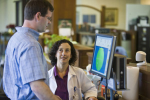 Candid photo of an ALS patient using a computer interface in a research setting.