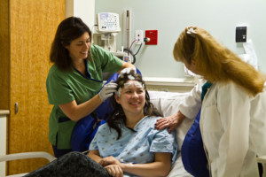 A female participant and medical practitioners in a clinical research setting.