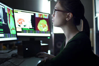 Image of student examining brain scans on computer