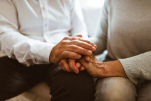 Elderly man and women holding hands - Caring for Alzheimer’s patients brings new challenges for some men